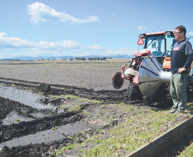 大豆栽培を予定する転作田の準備を進める大友代表（宮城県名取市で）